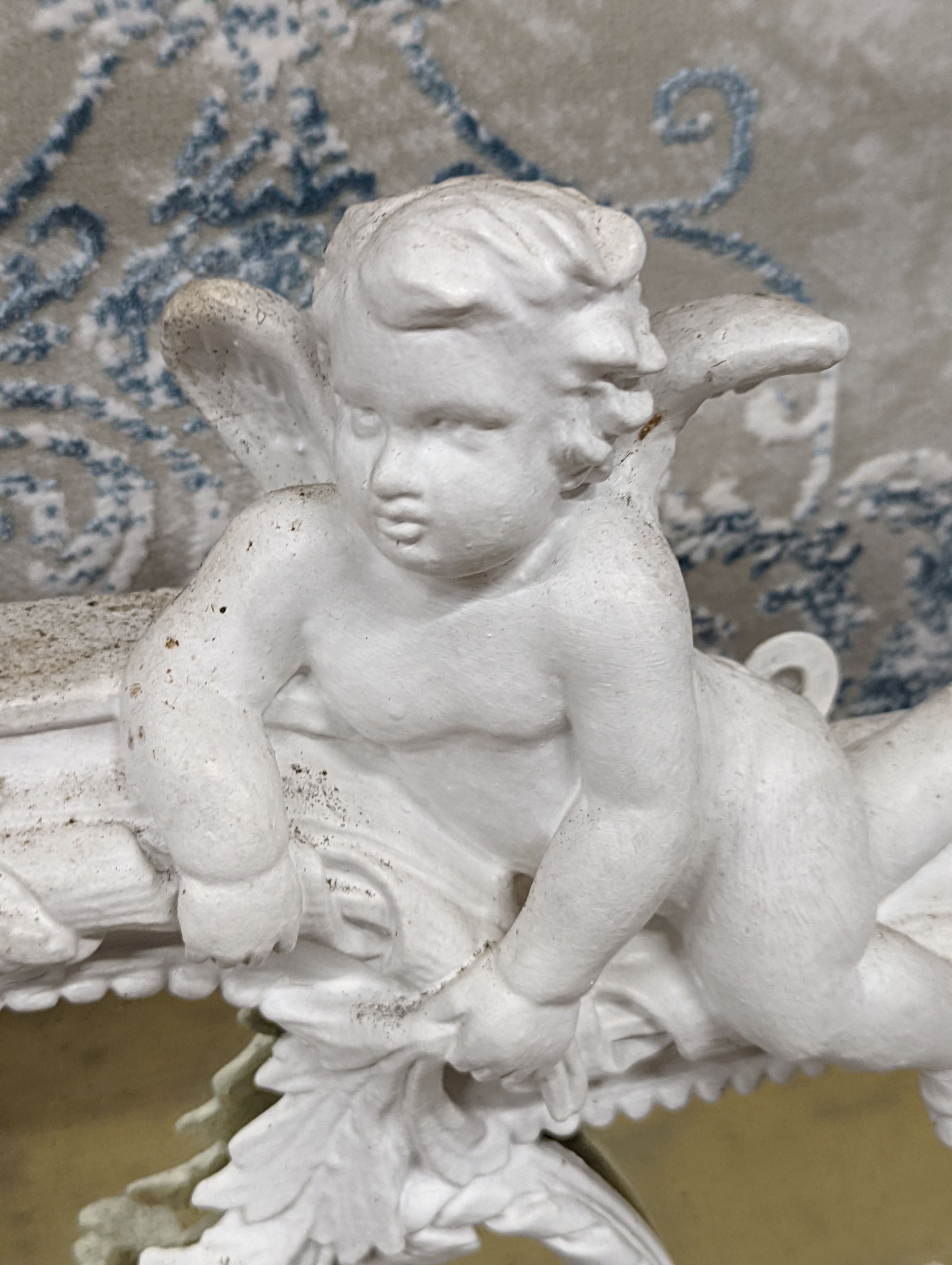 An Edwardian carved wood and gesso overmantel with cherub surmount, later painted white, width 188cm, height 96cm and a two white painted door pediments in need of restoration